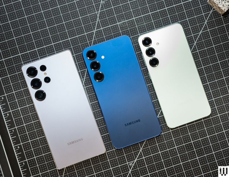Tres teléfonos móviles Samsung uno al lado del otro en plata, azul y blanco (de izquierda a derecha respectivamente), mostrando sus cámaras.