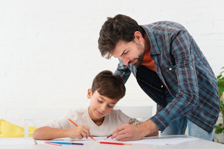 Padre Mirando Su Hijo Haciendo La Tarea