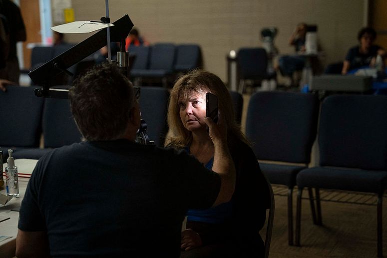 Un médico examina el ojo de un paciente con la linterna de un iPhone en una clínica de salud gratuita de AMEN (Red de Evangelismo Médico Adventista) en la Iglesia Adventista del Séptimo Día Asheville Foster, el 27 de junio de 2025, en Asheville, Carolina del Norte.
