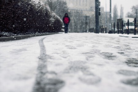 Tiro De Angulo Bajo De Una Persona Que Camina Sobre La Acera Cubierta De Nieve Bajo La Nieve