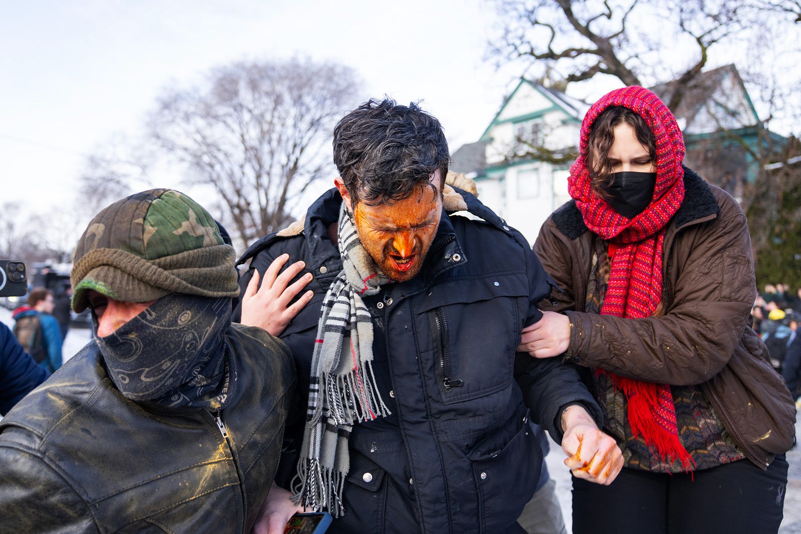Un hombre es ayudado por otras personas tras ser alcanzado por el spray de pimienta disparado por un agente federal....