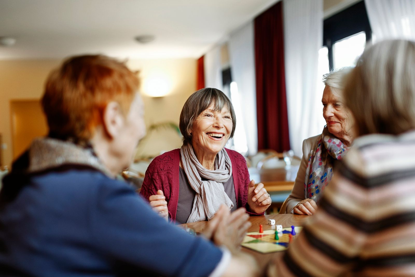 Mujeres mayores jugando a un juego de mesa en un hogar de ancianos.
