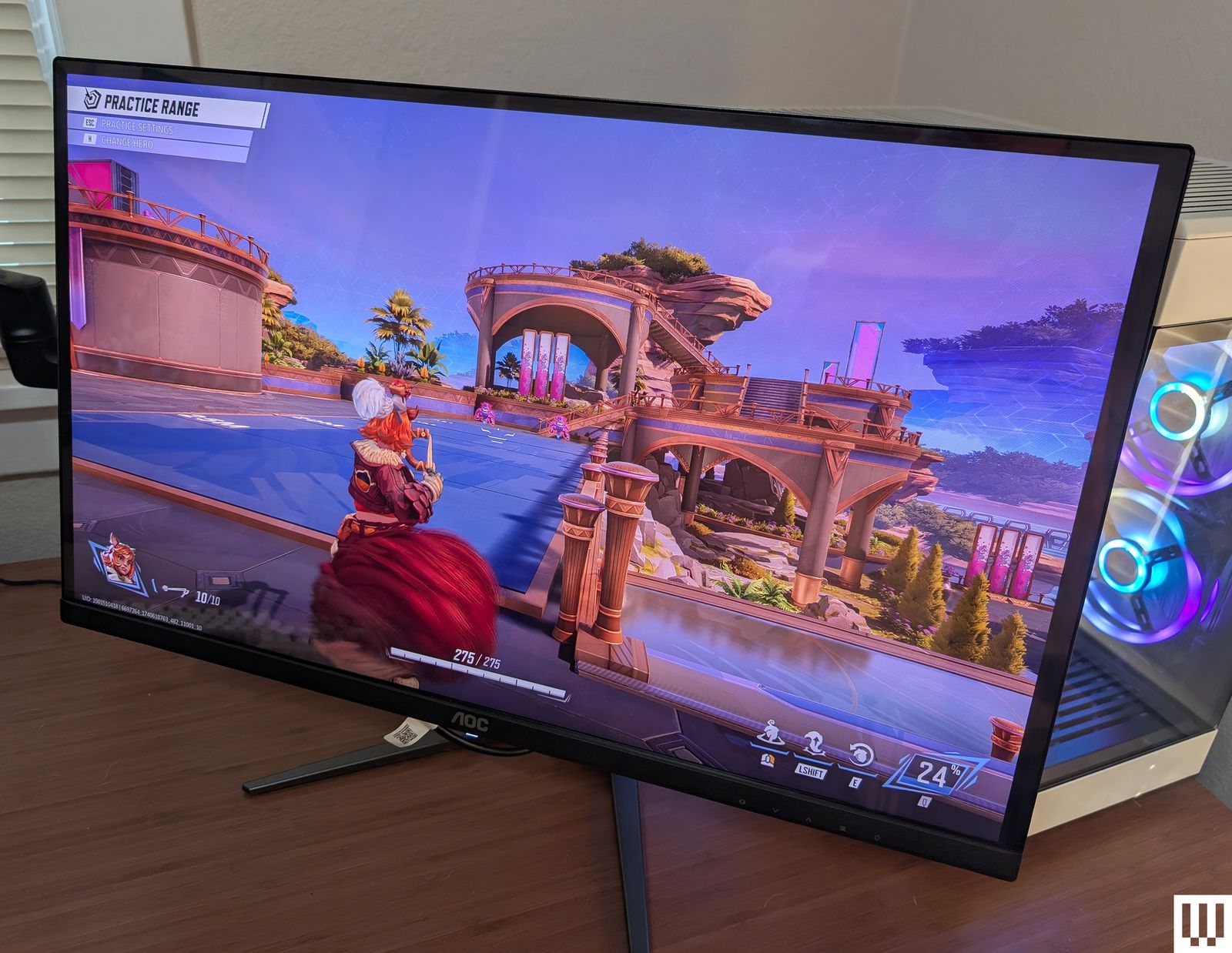 Vista frontal del monitor para videojuegos AOC Q27G4ZD QDOLED colocado sobre un escritorio de madera con la pantalla...