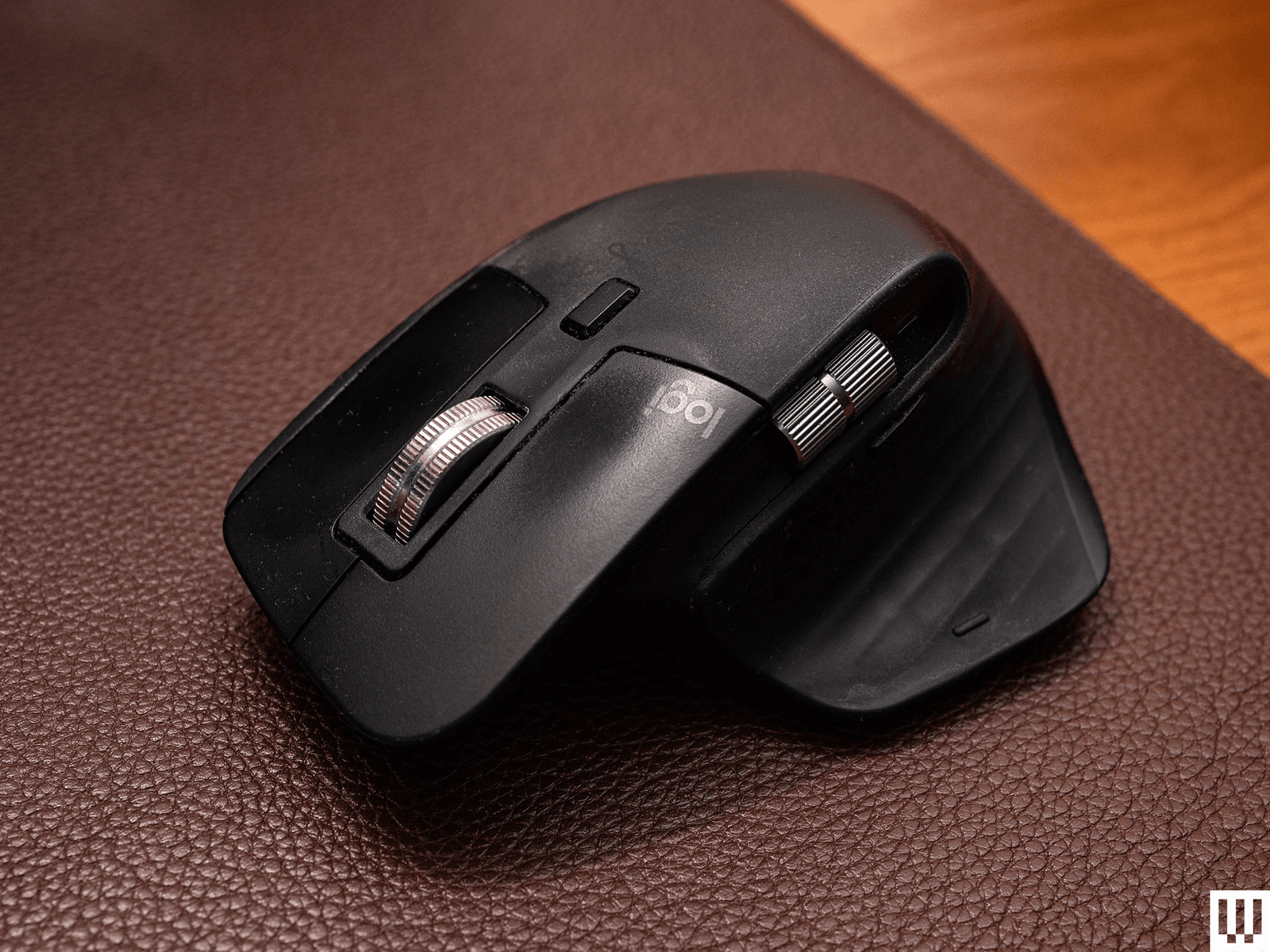 Logitech MX Master 3S un mouse de computadora negro sobre una alfombrilla de piel